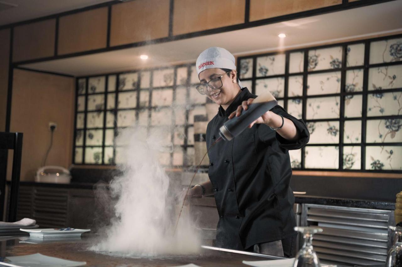 فندق راديسون بلو الرياض المظهر الخارجي الصورة A chef dusting a dish with powdered sugar